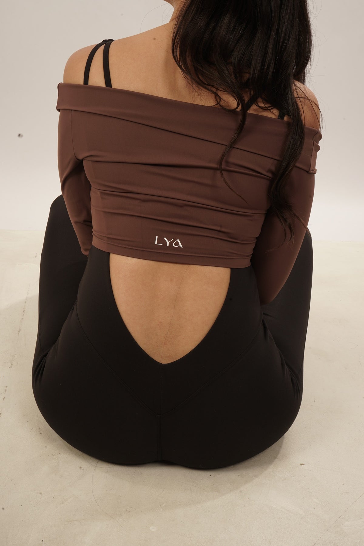 Detalle de espalda con top chocolate y prenda negra Aura