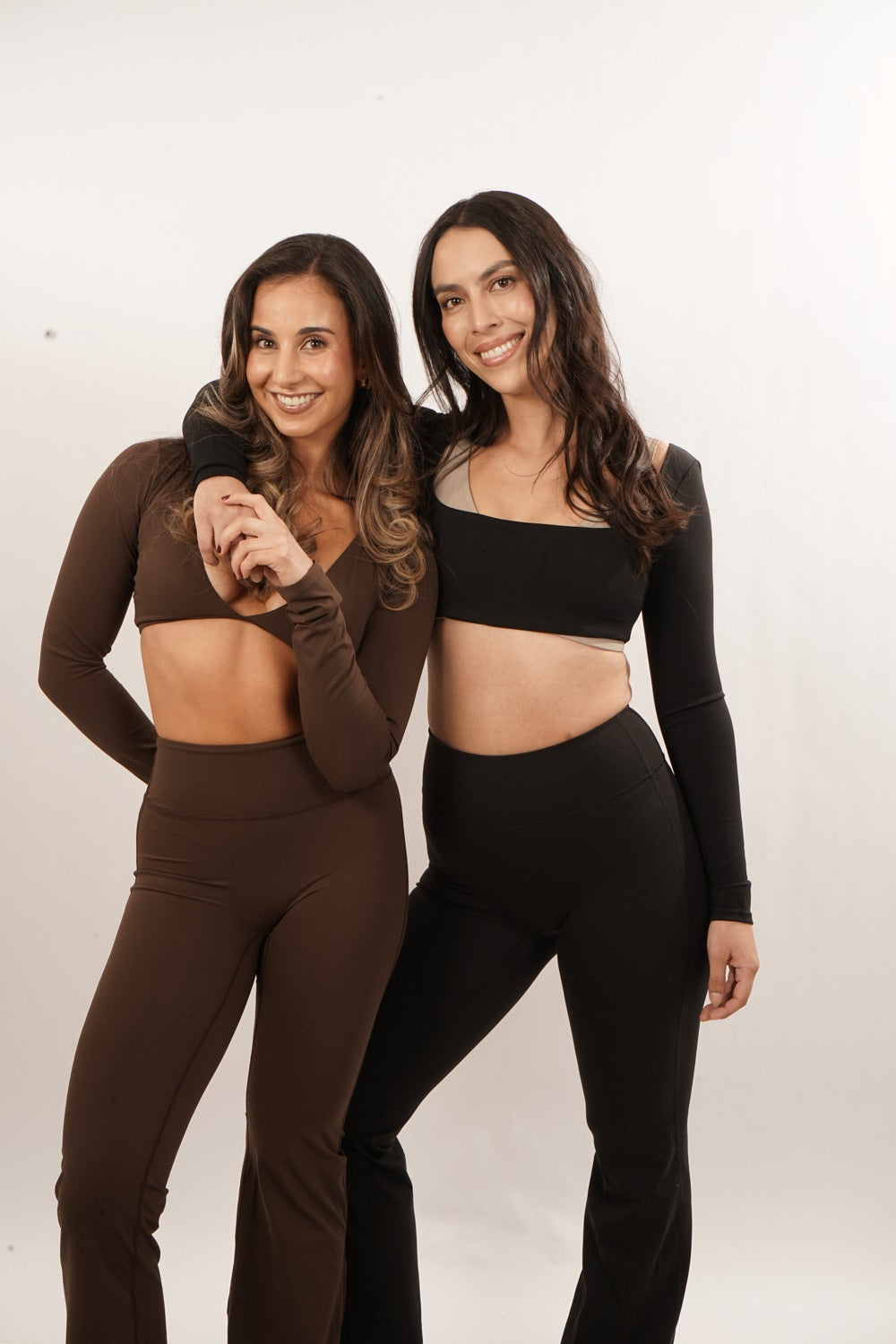 Dos modelos con tops y calzas Aura en chocolate y negro